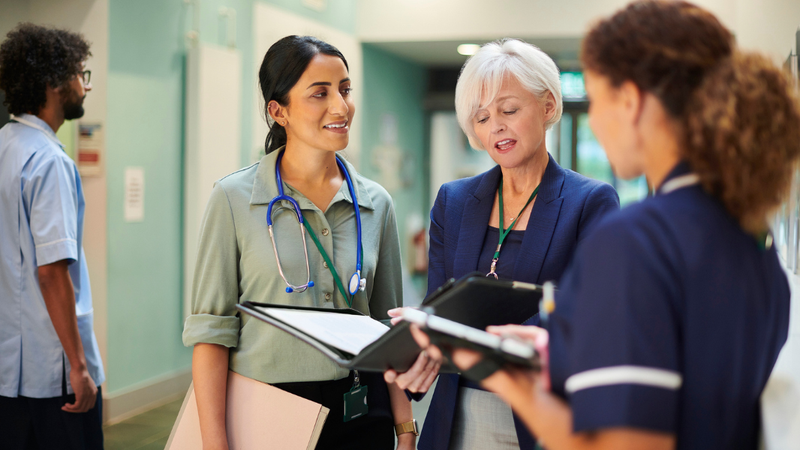 Group of female clinicians chatting in a corridor