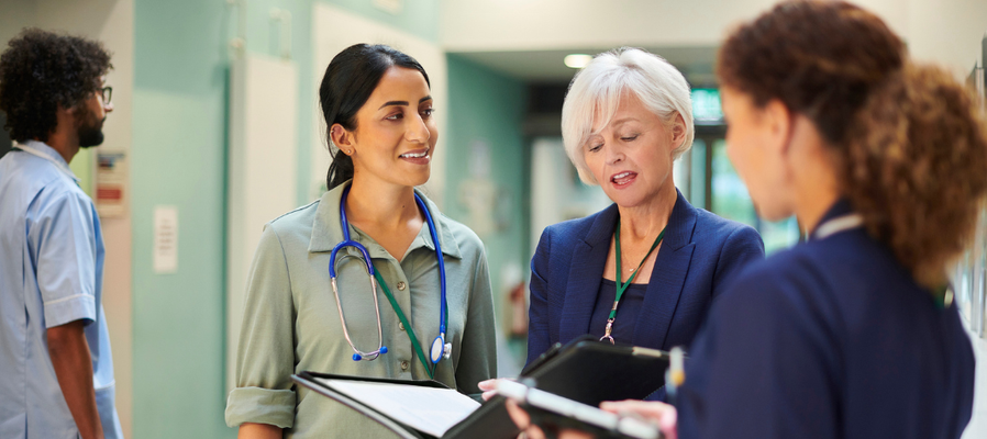 Group of female clinicians chatting in a corridor