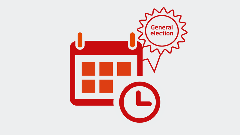 A calendar and clock, with general election rosette in the background