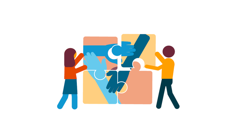 Two people holding together a jigsaw