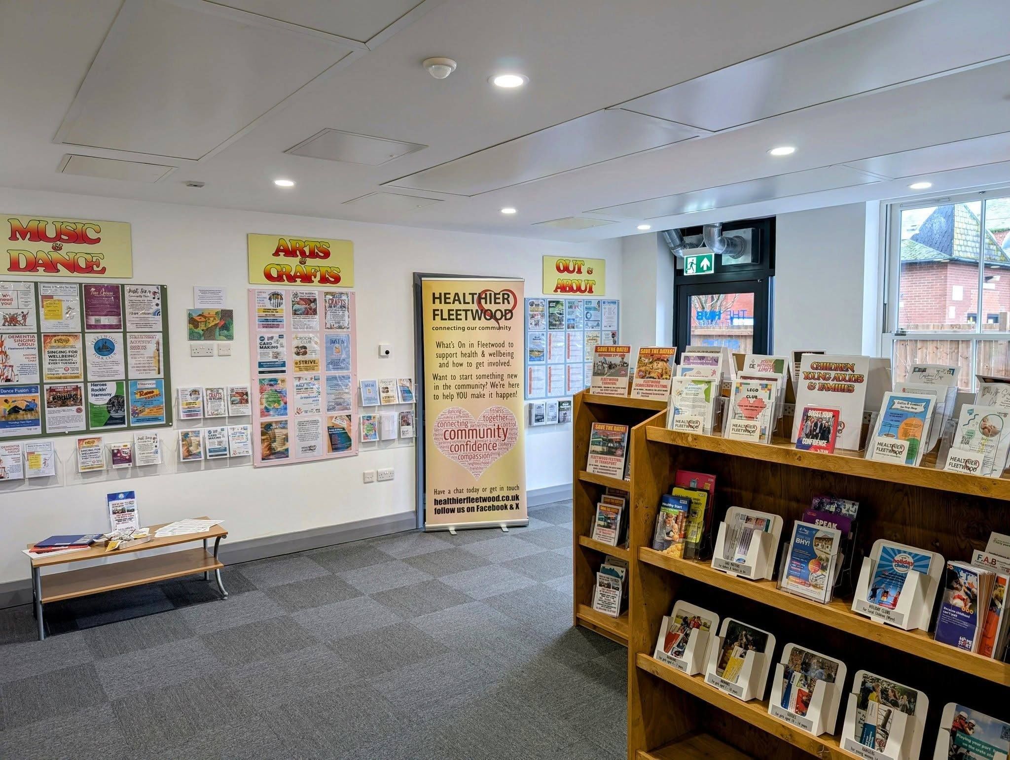Community center interior with pamphlets on shelves and event posters on walls under 