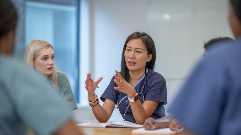 Medical practitioners in conversation sitting at a table
