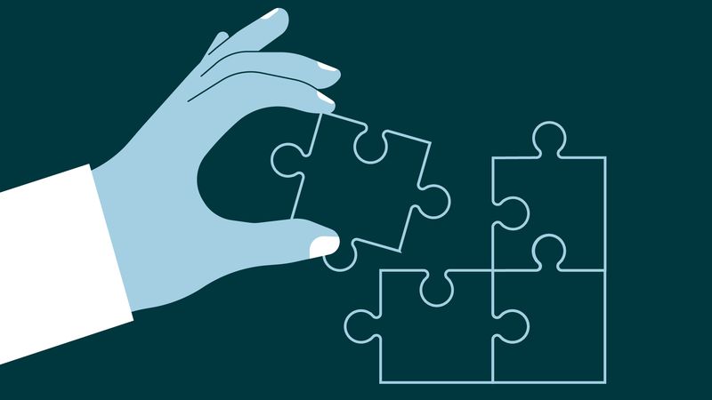 Hand putting the final piece in a jigsaw