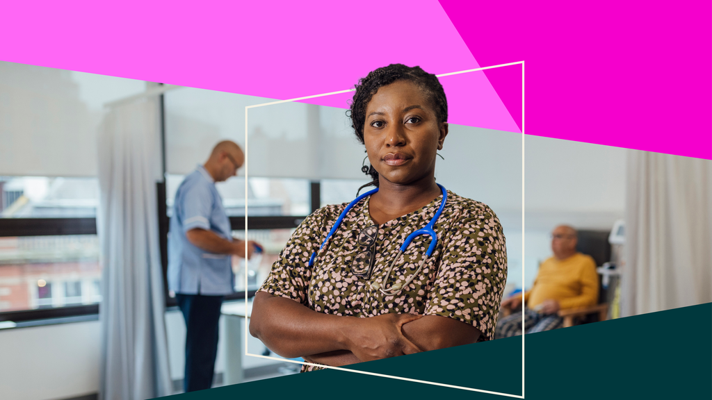 A doctor in a medical setting looks confidently toward the camera. She is standing with her arms folded and a blue stethoscope round her neck.